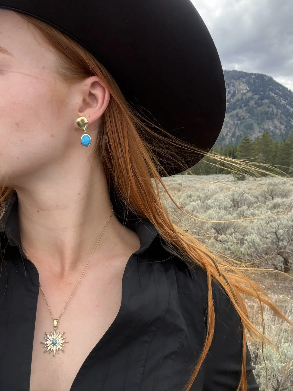 Turquoise drop earrings and turquoise sun necklace with a black cowboy hat